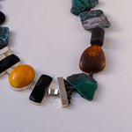 Load image into Gallery viewer, Collana con elementi di crisocolla semi opaca, onice, ambra opaca, pietra lavica ed elemento in resina.
